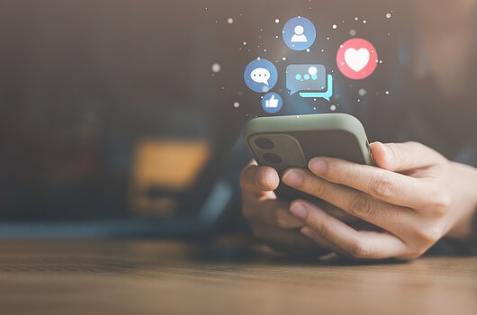 Social media and digital online concept, woman using smart phone on sofa at home. The concept of living on vacation and playing social media.